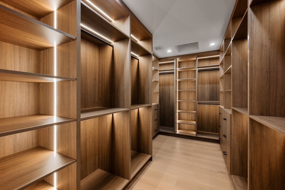 Dressing luxueux en bois avec éclairage LED intégré et étagères design pour un aménagement de placard moderne.