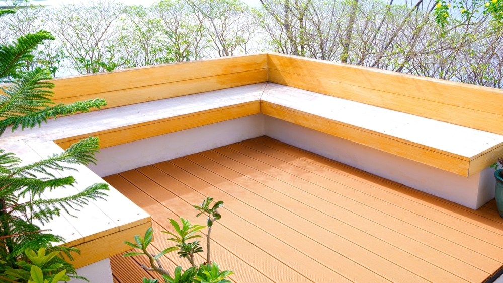 Terrasse en bois avec banquette : design extérieur moderne Terrasse moderne avec banquette en bois clair en L, sol en lames composites et plantes décoratives.