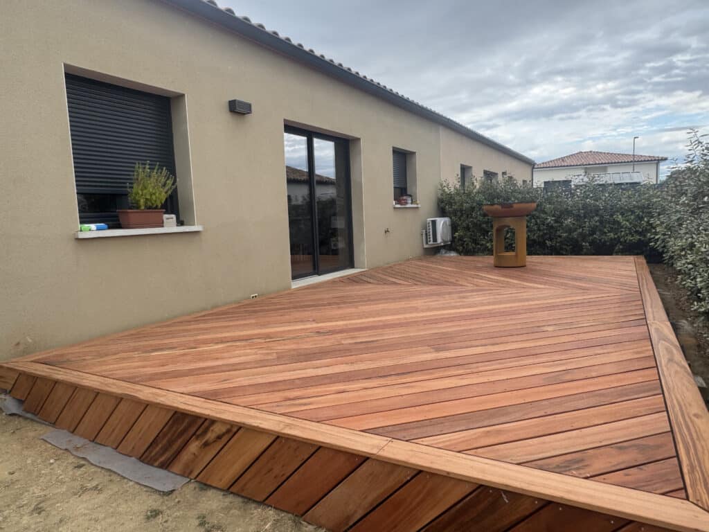 Terrasse en bois exotique massif avec motif géométrique devant une maison contemporaine.